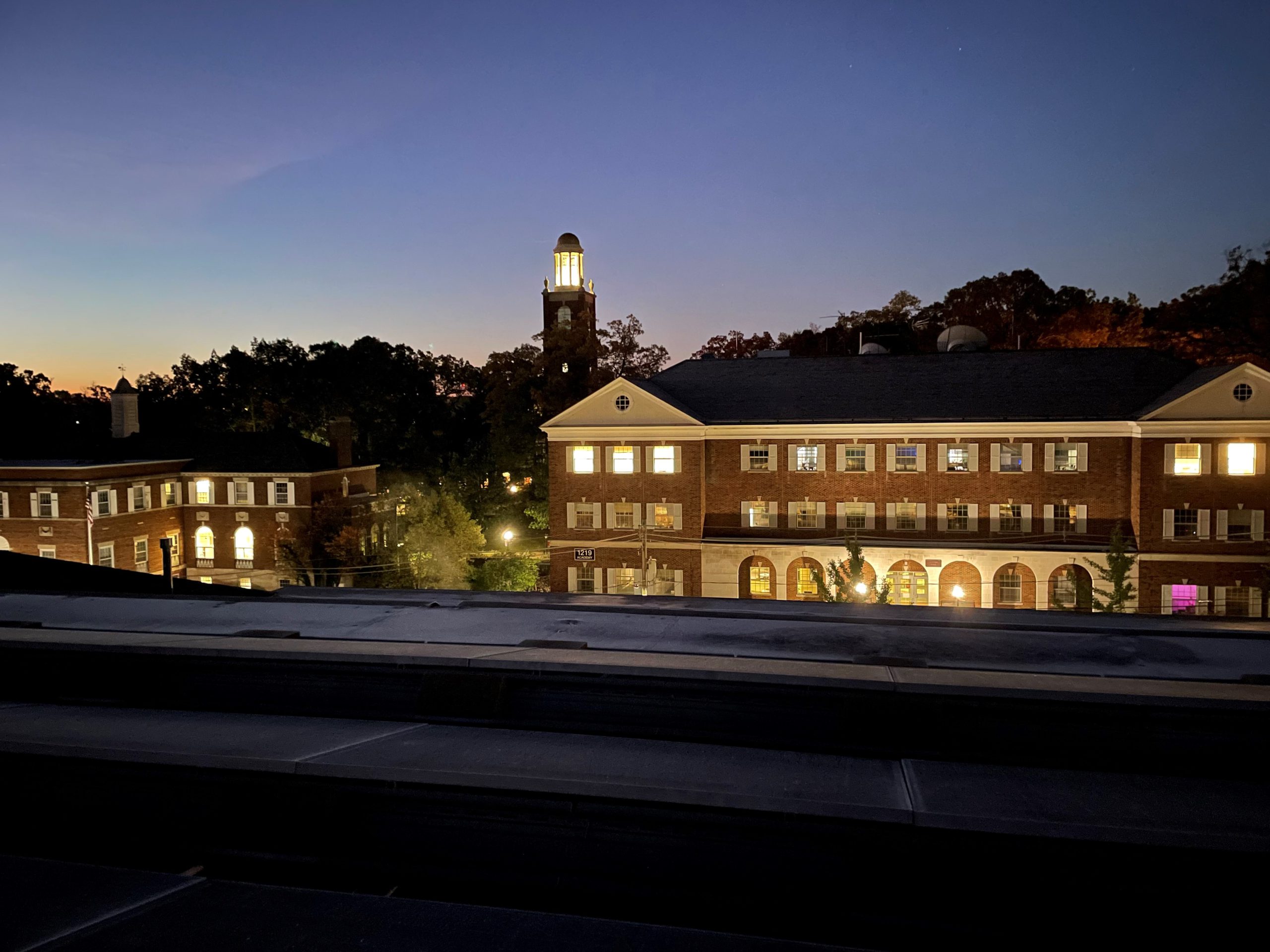 Picture of Dewing and Mandelle from the Rooftop of the Library with Stetson Chapel illuminated in the back.